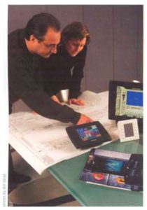 Two people examining architectural plans and devices.