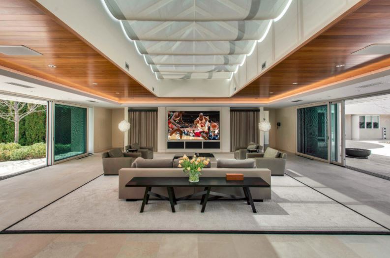 Modern living room with large TV and comfortable seating.